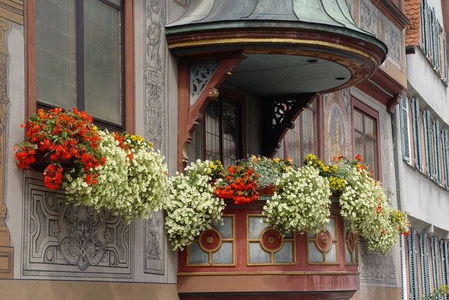 Malý balkón vyzdobený množstvom kvetov.jpg